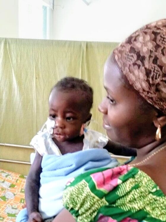 A mother holds her baby on a hospital ward during cancer treatment.